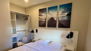 A hotel room with a bed, a wardrobe, a headboard with artwork, and a nightstand. - Apartment for 4 with terrace, garden, pool and beach access - Pets allowed (La Tranche-sur-Mer)