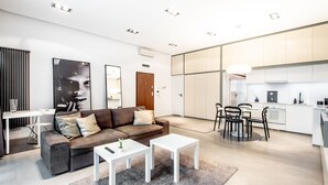 Een moderne woonkamer met een bank, salontafel en een eethoek.