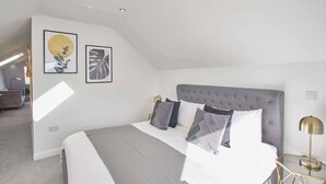 A modern hotel room with a large bed, a bedside table, and a lamp. - Host & Stay | The Penthouse, Hudsons Yard House (Whitby)