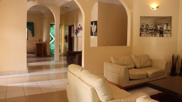 Amplia sala de estar con un sofá color beige, una mesa de centro y un cuadro en la pared.