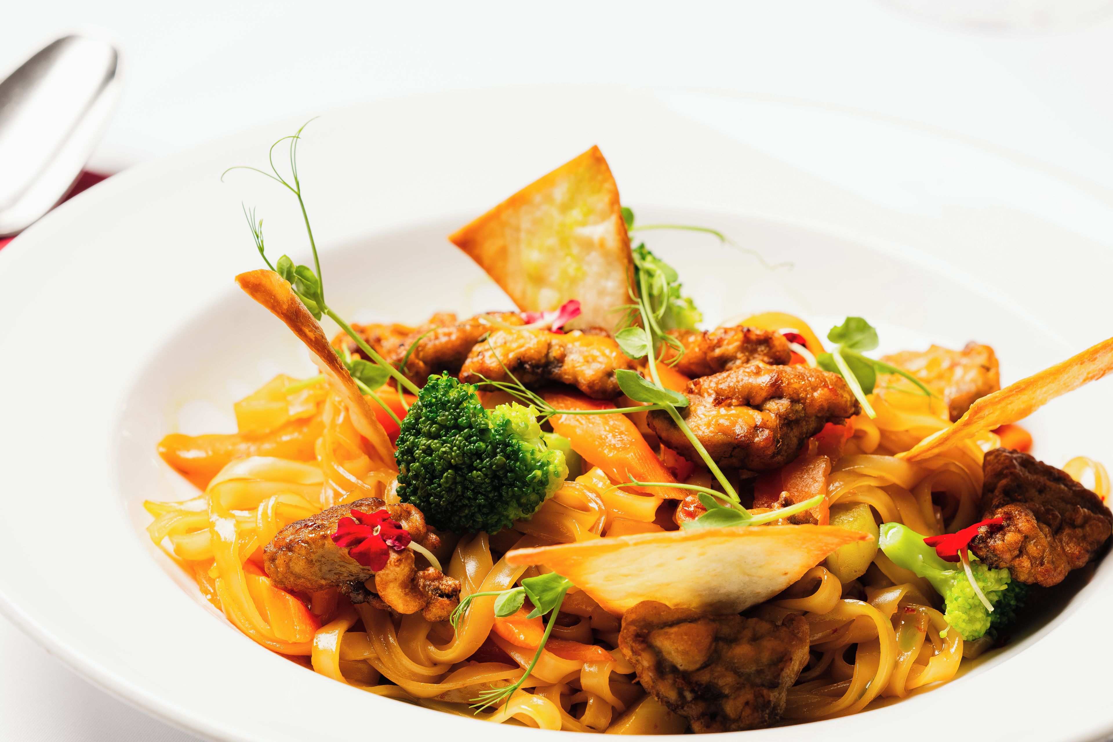 A plate of food with noodles, vegetables, and meat.