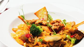 A plate of food with noodles, vegetables, and meat.