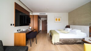 A hotel room with a bed, a desk, a chair, a television, and a bathroom. - Mikado Hotel (Nitra)