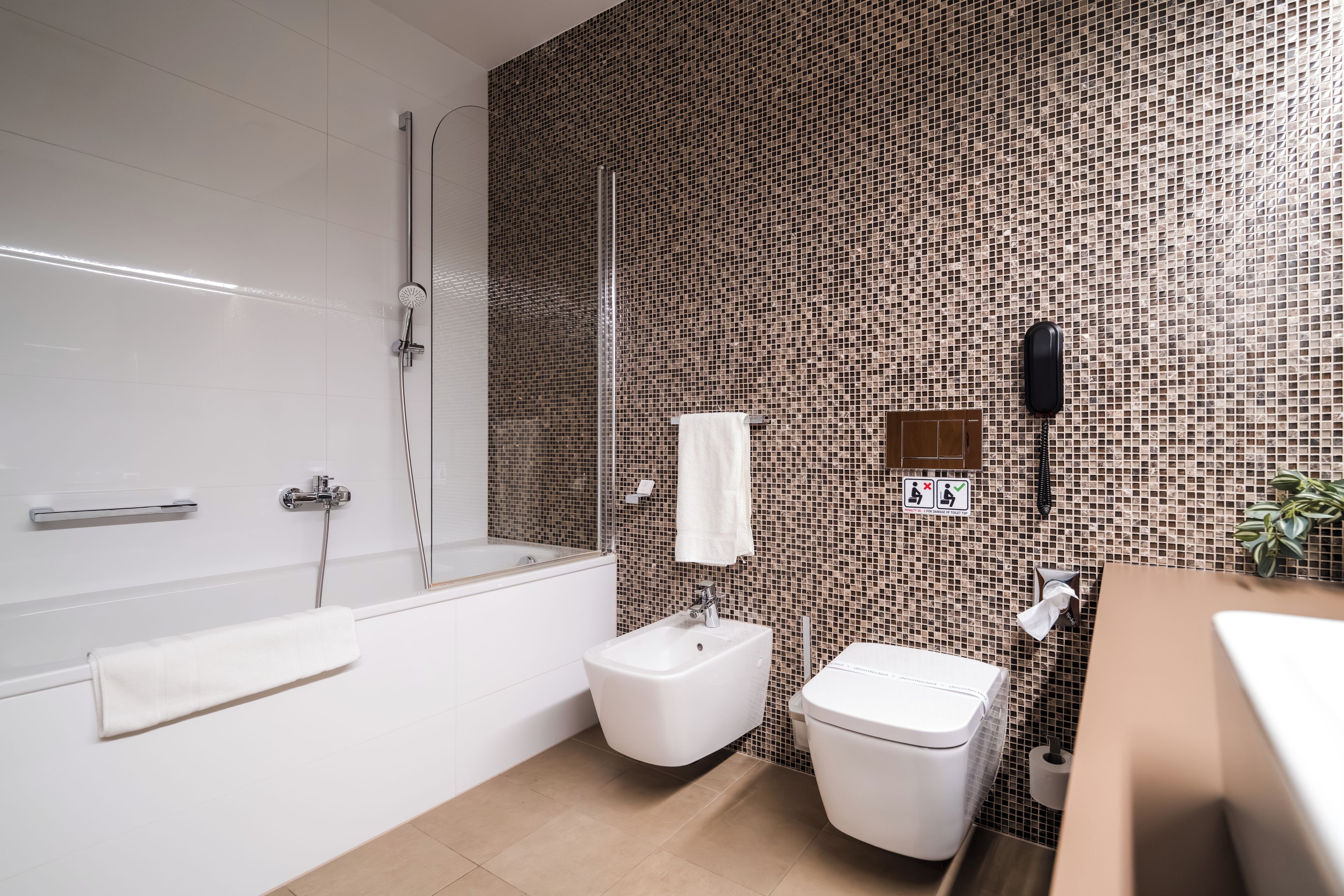A modern bathroom with a bathtub, a toilet, and a sink.
