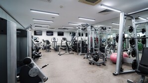 A gym with various exercise equipment, including treadmills, weight machines, and free weights. - Mikado Hotel (Nitra)