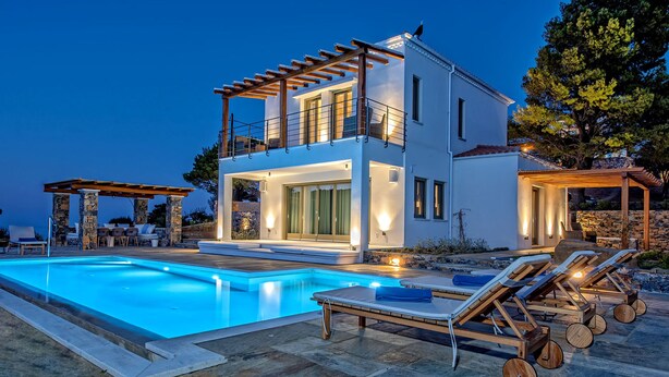 A modern two-story house with a swimming pool, outdoor seating, and a pergola. - Stargaze Villas (Skopelos)