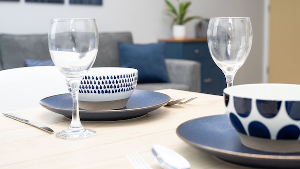 A dining table with a bowl and two wine glasses, a fork, and a spoon. - Spa Court (Cheltenham)
