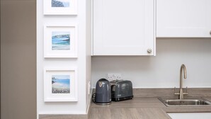 A kitchen with a modern sink, two electric kettles, and a toaster. - Spa Court (Cheltenham)
