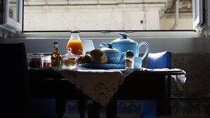 A table with breakfast items and a view of a clock tower through a window. - Lisbon Calling (Lisbon)