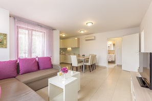 Un appartement moderne comprenant un salon, un coin repas et une cuisine.
