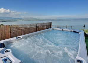 Uma banheira de hidromassagem com vista para um lago e montanhas.