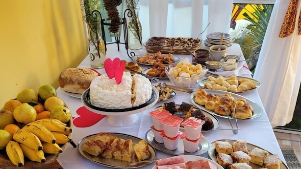 A buffet table with various food items including fruits, pastries, and cheeses. - Pousada Vida e Natureza (Gramado)