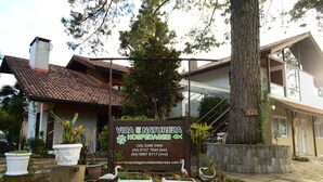A signboard for Vida e Natureza Hospedagem with contact numbers and a website URL. - Pousada Vida e Natureza (Gramado)