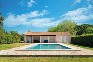Una piscina al aire libre de temporada, sillones reclinables de piscina