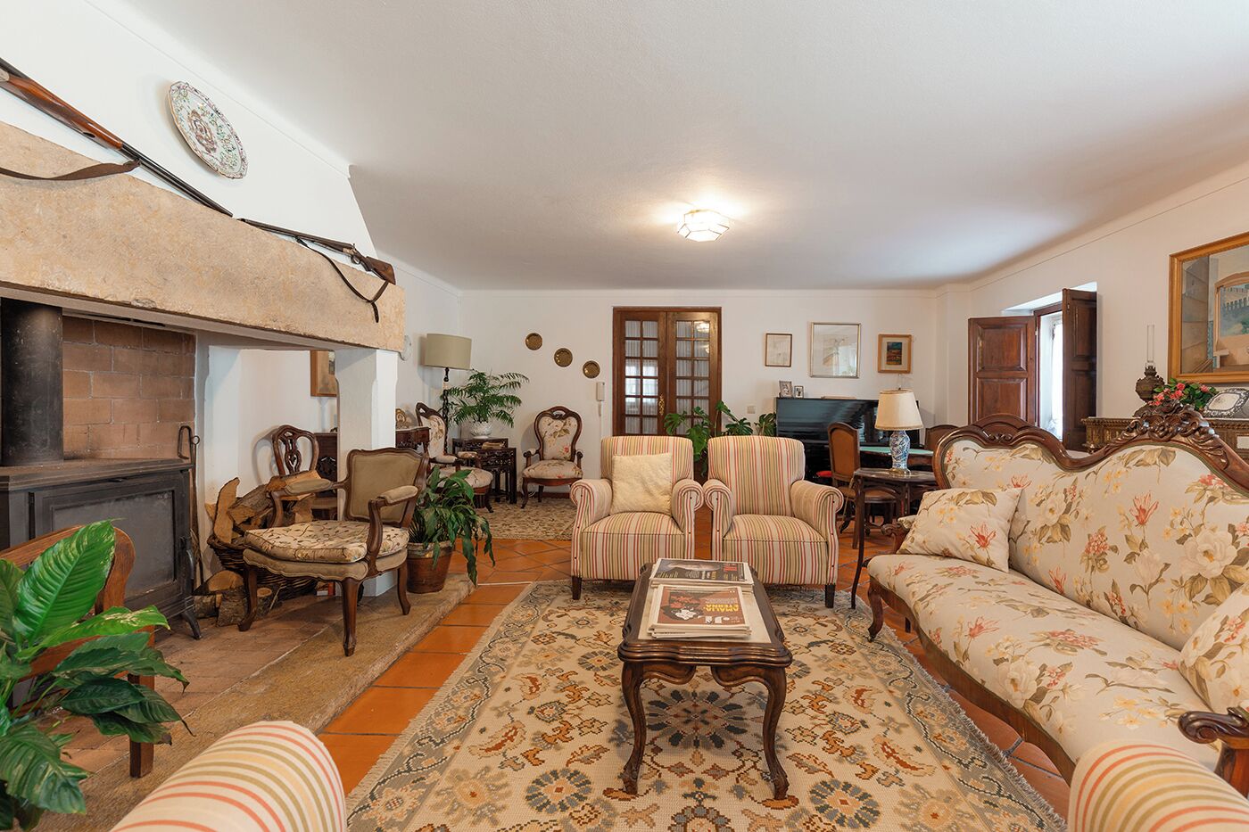 Una sala de estar acogedora con chimenea, asientos cómodos, un televisor y elementos decorativos.