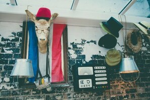 A room with a brick wall, a mounted animal head, and a security keypad.