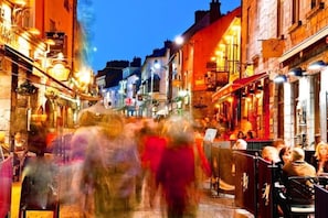 A bustling street scene with people walking and dining at outdoor cafes. - Unique Fairytale Farmhouse Near Galway (Corrandulla)