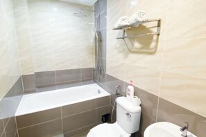 Bathroom features a large bathtub, toilet, and sink.