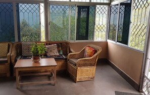 Relax in this inviting space with a wicker sofa, armchair, and potted plant.