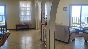 A spacious living area with a tiled floor, a dining table with chairs, a sofa, and a ceiling fan. - Amazing views, relax far away from snow. Fantasy Vacation Planning Available. (St. Thomas)