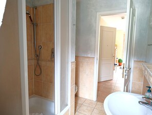 Une salle de bain avec douche, toilettes et lavabo.