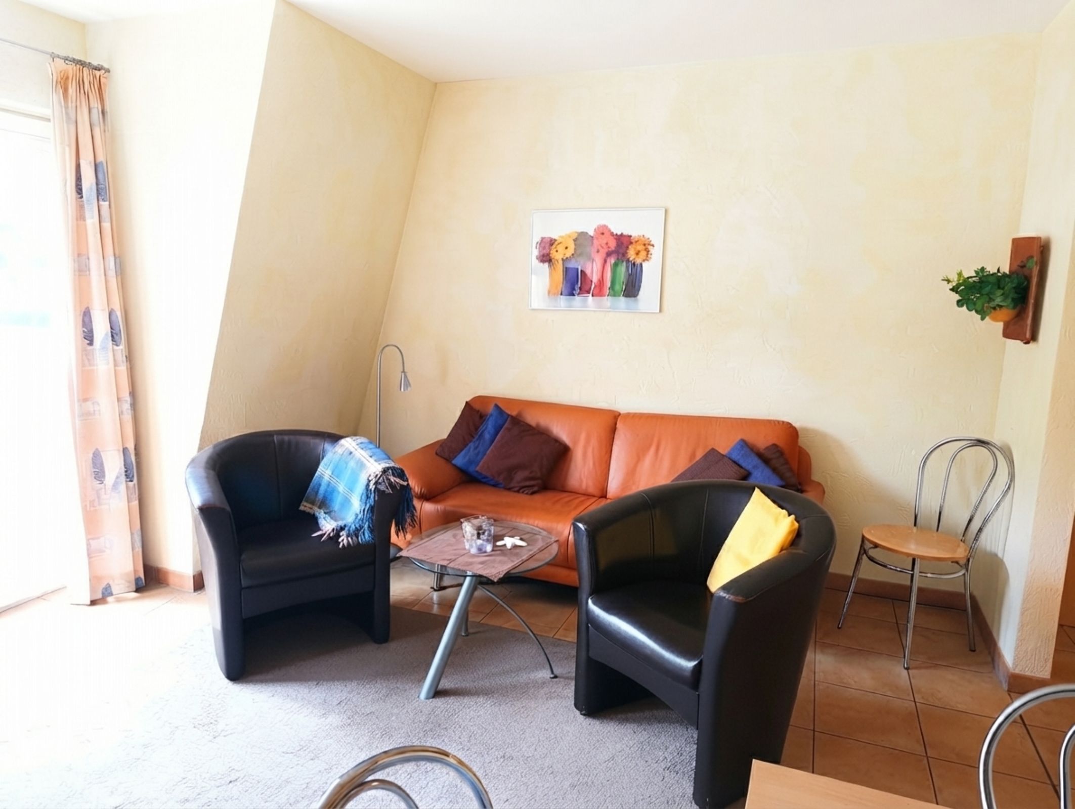 Ein Wohnzimmer mit einer Couch, zwei Sesseln, einem Couchtisch, einer Dusche und einem Topfpflanze.