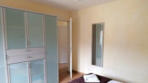 A bedroom with a bed, a wardrobe, and a bathroom door.