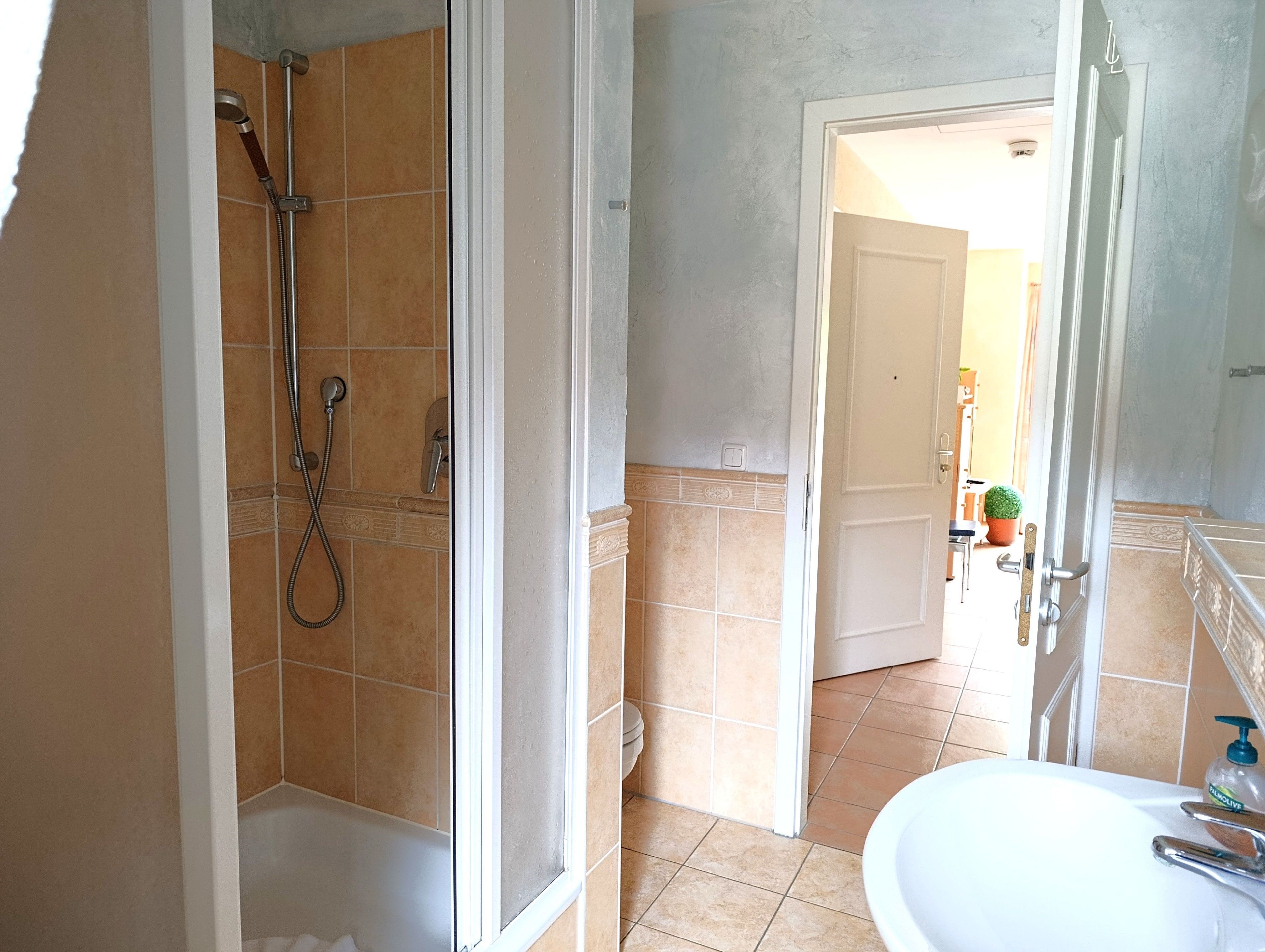 Ein Badezimmer mit Dusche, Toilette und Waschbecken.