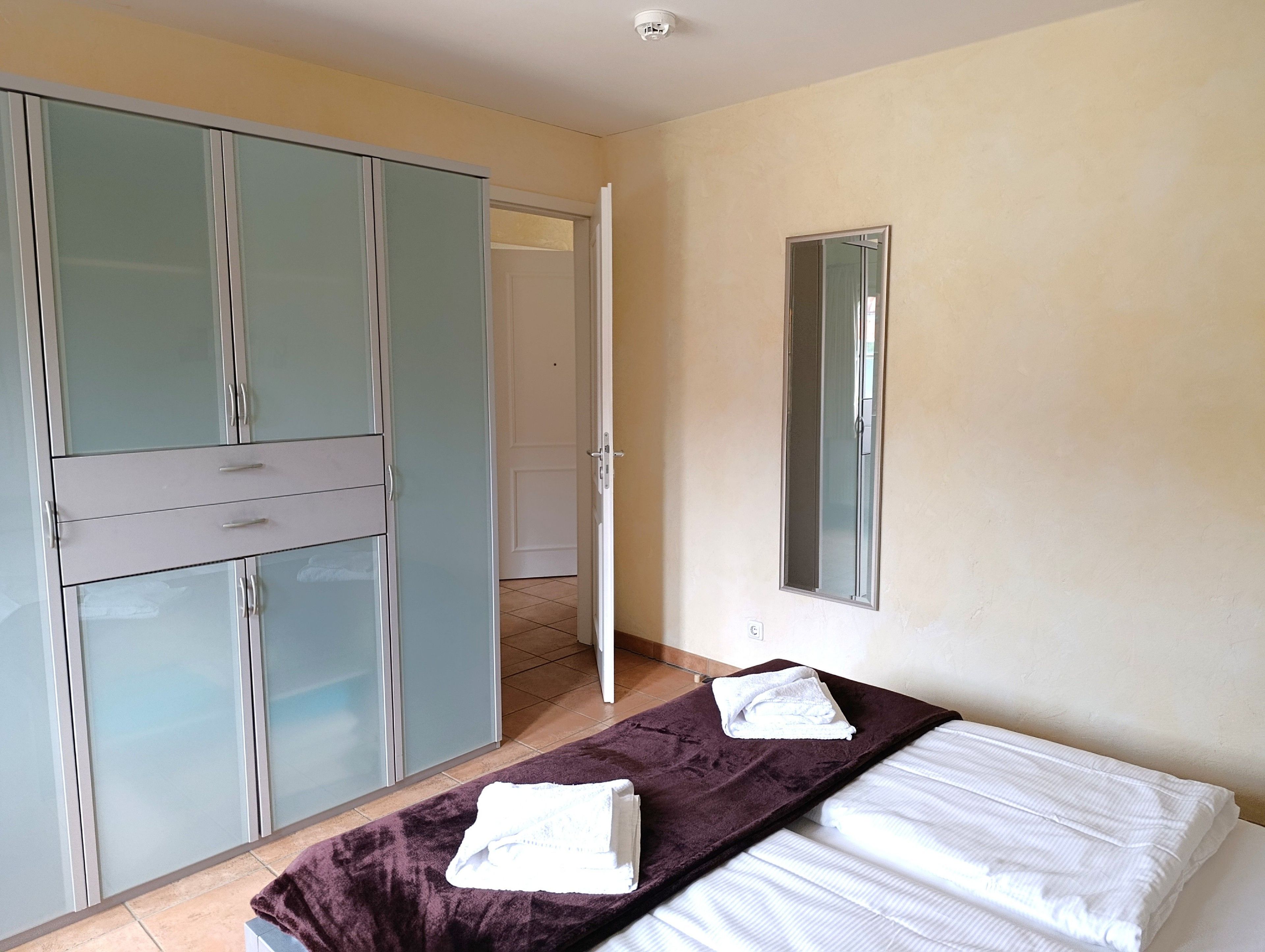 Ein Schlafzimmer mit Bett, Schrank und Badezimmertür.