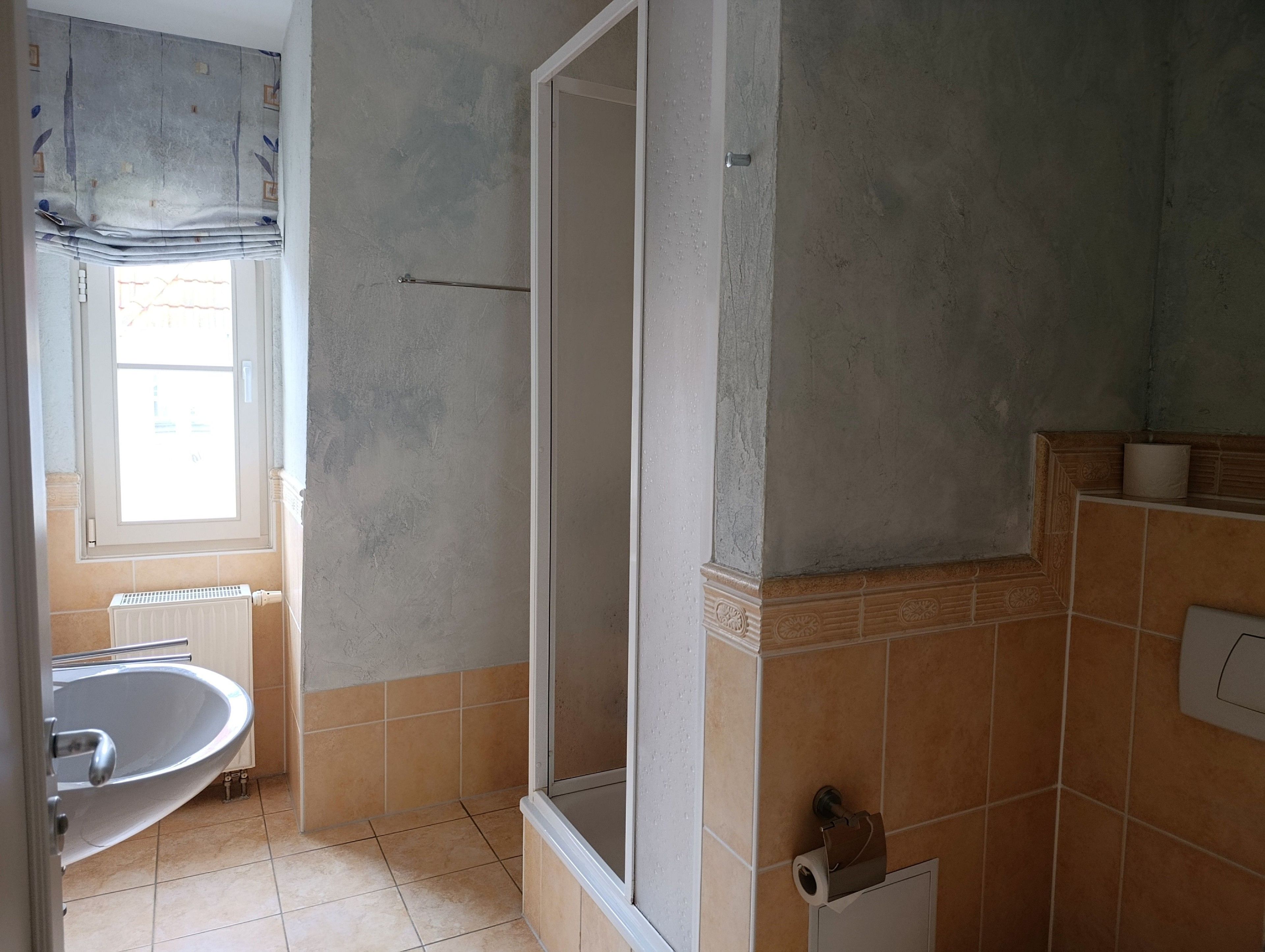 Un baño con ducha, lavamanos e inodoro.