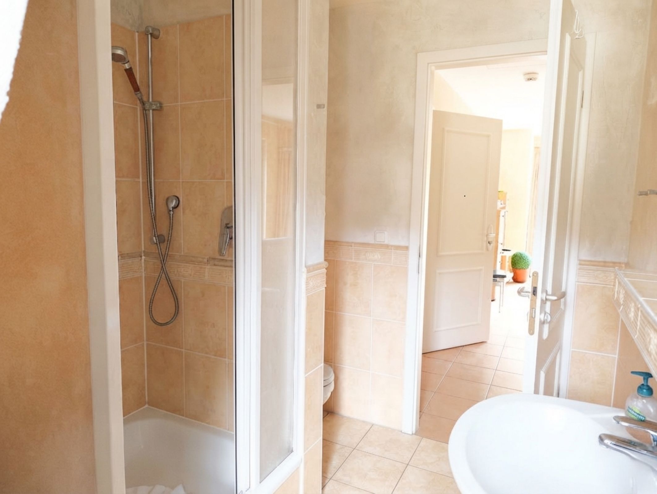 A bathroom with a shower, toilet, and sink.