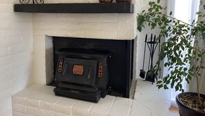 A fireplace with a black mantel, a decorative copper kettle, and a brass tea pot. - Spacious centrally located peaceful house Red Rock views and a fenced dog yard! (Sedona)