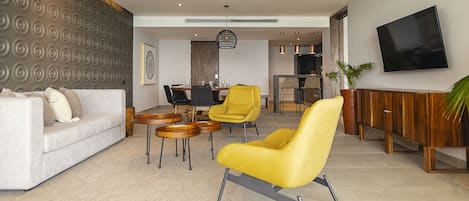 Un salon moderne avec un canapé, un fauteuil jaune et un coin repas.