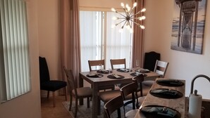En matplats med ett bord i marmor, stolar och en kristallkrona.