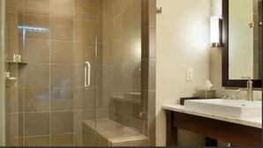 A bathroom with a glass-enclosed shower, a sink, and a mirror. - Enjoy a Pre-Holiday vacation in Historic Savannah (Savannah)