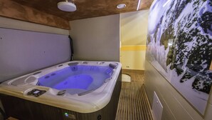 A hot tub with a control panel, wooden paneling, and a wall-mounted picture of a snowy landscape. - Guesthouse Vodnik (Cerklje na Gorenjskem)
