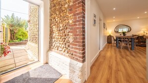 Eine moderne Küche mit einer Steinwand, Holzboden und einem Essbereich mit Tisch und Stühlen.