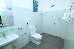 A small, clean bathroom with a toilet, sink, and shower.