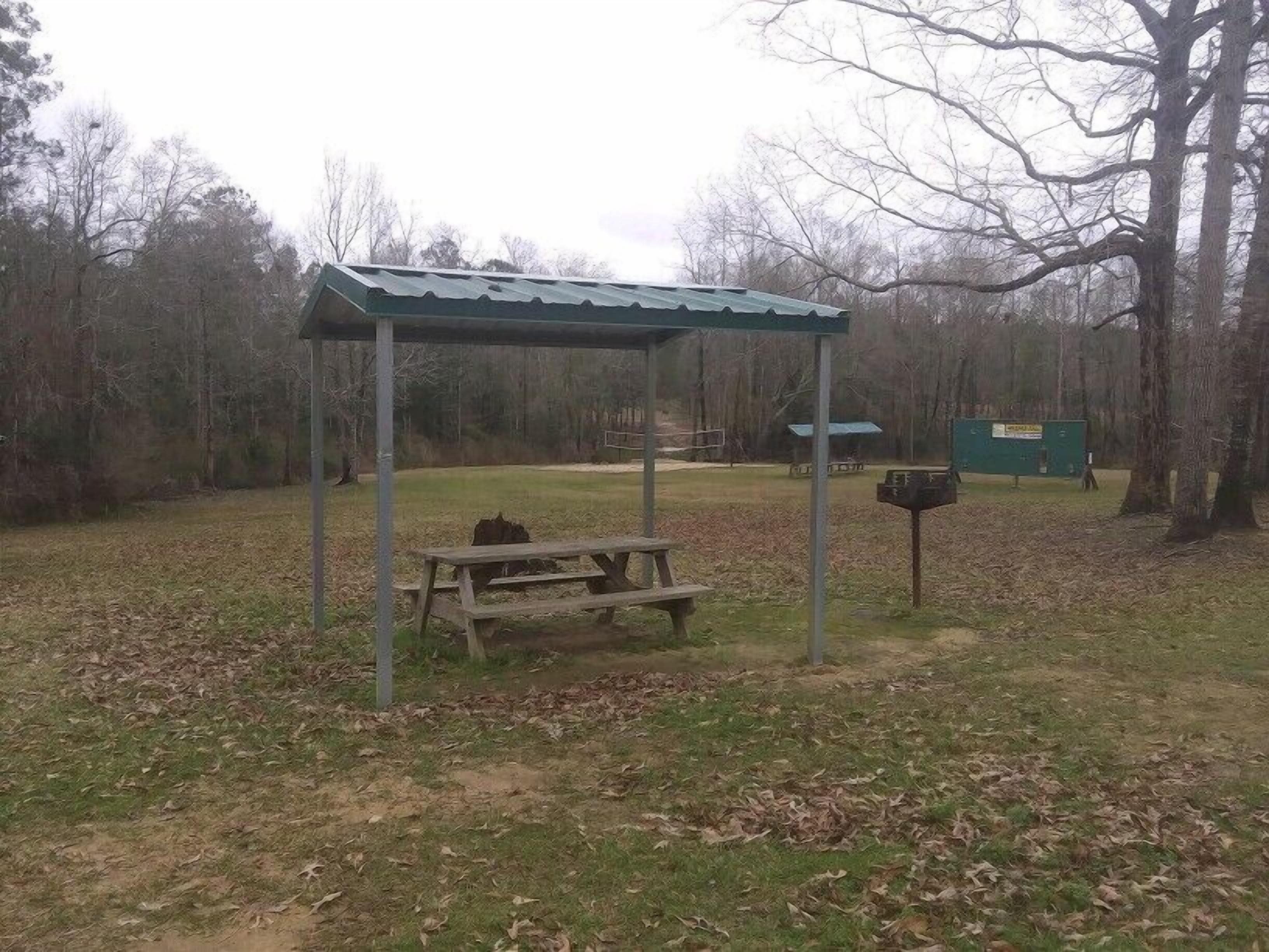 Un área de picnic con banco y un refugio cubierto.