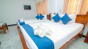 A hotel room with two beds, each with blue and white bedding, and a wooden headboard. - Hotel Sun Blue - Purity in paradise (Alas Garden Trincomale Trincomale)