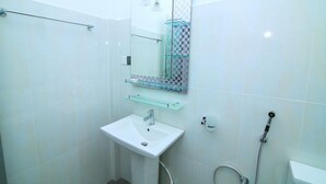 A modern bathroom with a white sink, a glass shower enclosure, and a tiled shower area. - Hotel Sun Blue - Purity in paradise (Alas Garden Trincomale Trincomale)