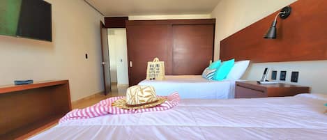 Une chambre d’hôtel dotée d’un grand lit, d’un bureau, d’une télévision à écran plat et d’une armoire.