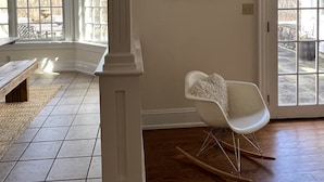A spacious room with a large window, a rocking chair, and a framed artwork on the wall. - Over Sized Colonial on Private Road.  (Pound Ridge)