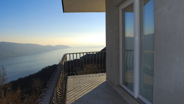 A balcony with a view of a lake and mountains.