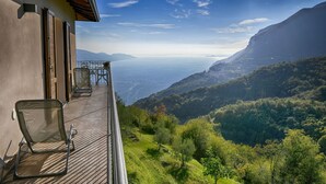 Un balcón con vistas a un paisaje montañoso y una masa de agua.