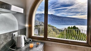 A kitchen with a view of a lake and mountains. - Armonia by Theater Home, with two parking spaces and beautiful lake view (Tignale)