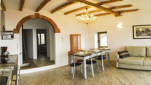 A spacious living area with a dining table, sofa, and a chandelier. - Gina by Theater Home, in the historic centre with beautiful lake view (Tignale)