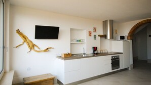 A modern kitchen with white cabinets, a built-in oven, and a coffee maker. - Menèk by Theater Home, in the historic centre (Tignale)