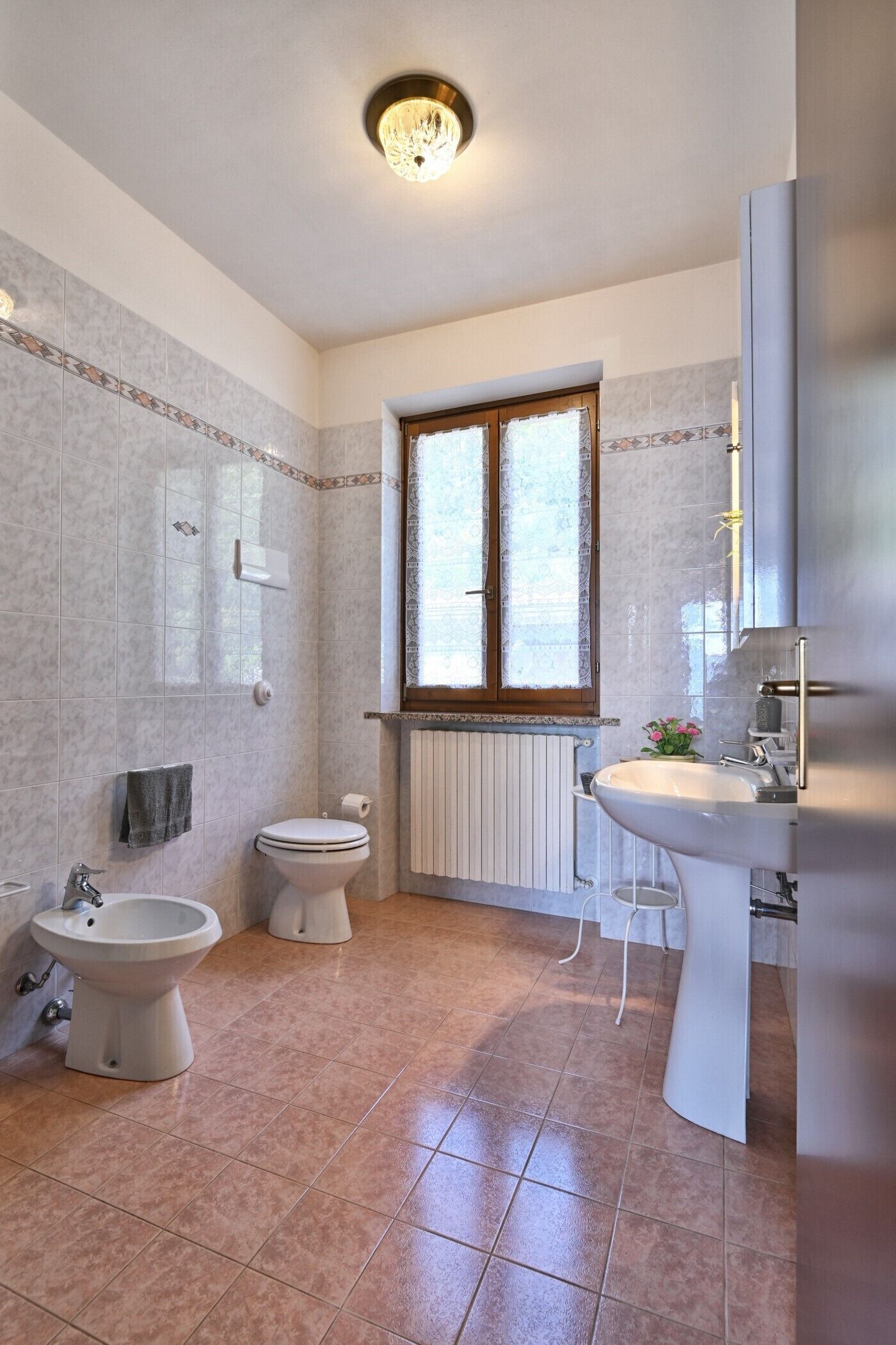 A bathroom with a bidet, toilet, and sink.