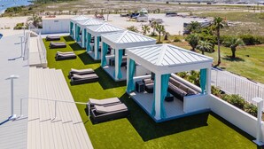 A rooftop deck with multiple lounge areas, each with a canopy and seating. - Large Four Bedroom Unit with Wraparound Balcony Views of the Courtyard! Complimentary Boat Slip! (Orange Beach)